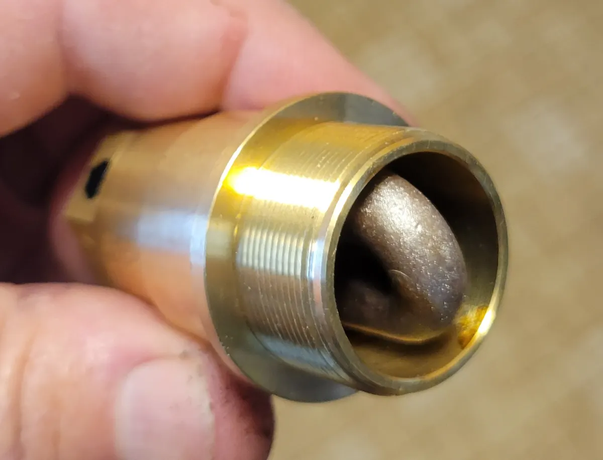 A frost-plug block heater element with its brass heating coil and mounting flange