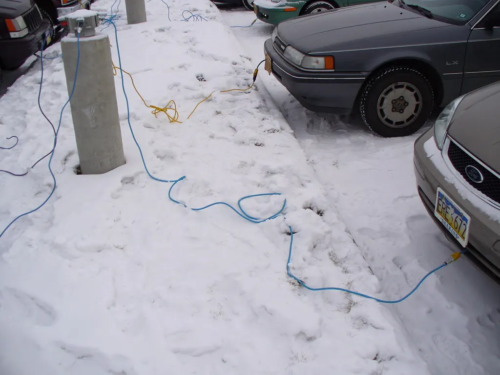 Cars plugged into outdoor parking-post outlets in subzero weather