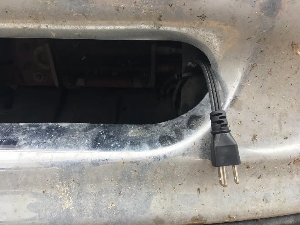 A factory block heater cord routed through a pickup truck grille
